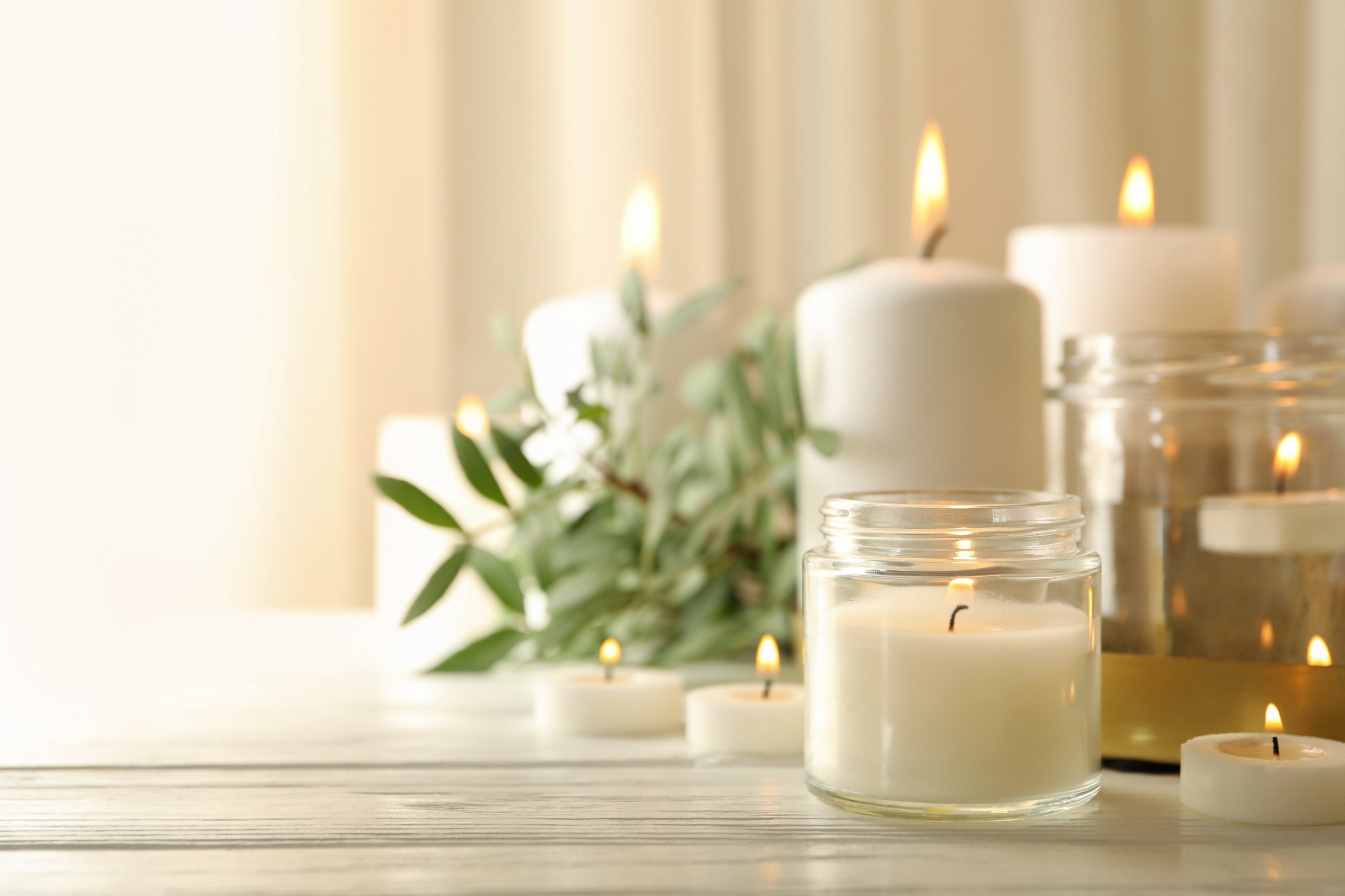 Burning scented candles for relax on white wooden table